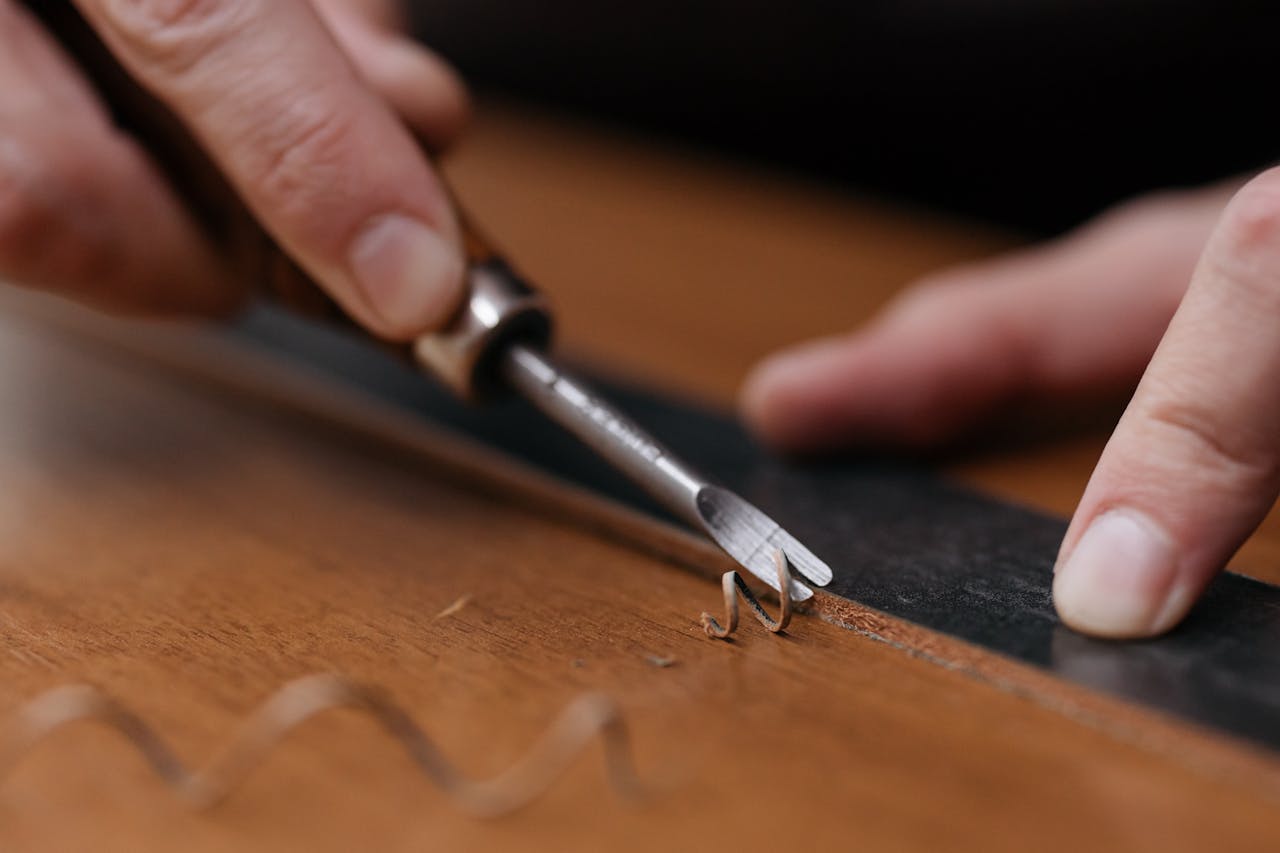 our-services-2 Close-up of hands carving wood with a chisel and ruler, showcasing fine craftsmanship.